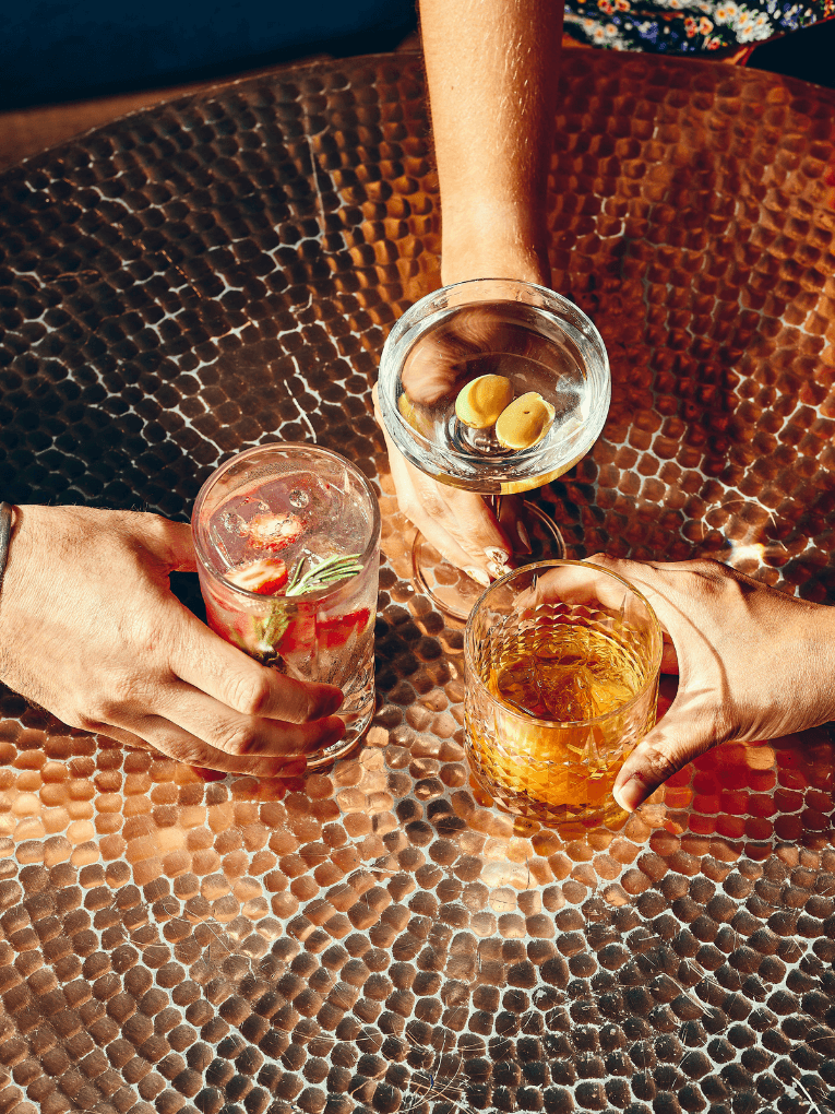 3 cocktails sitting on a copper table