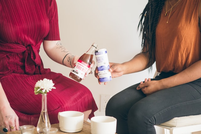 Two girls toasting with their drink