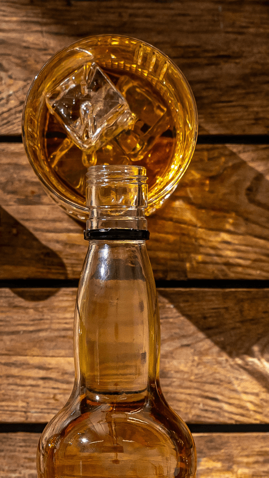 Scotch whisky being poured from bottle into a glass