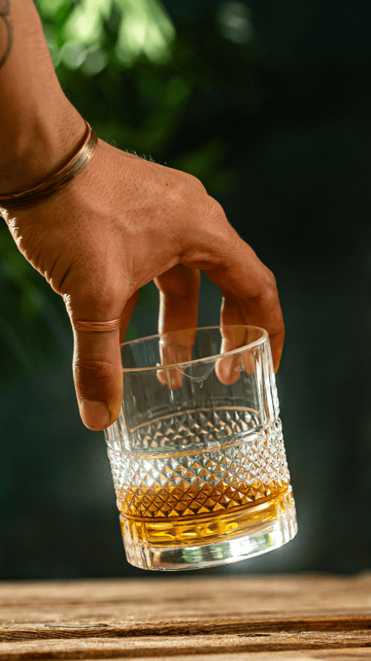 Hand holding a glass of scotch whisky