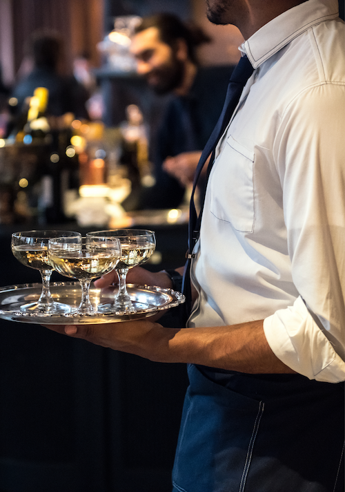 Bartended holding a tray of drinks